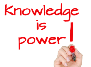 A hand writing on to of the words " knowledge is power ".